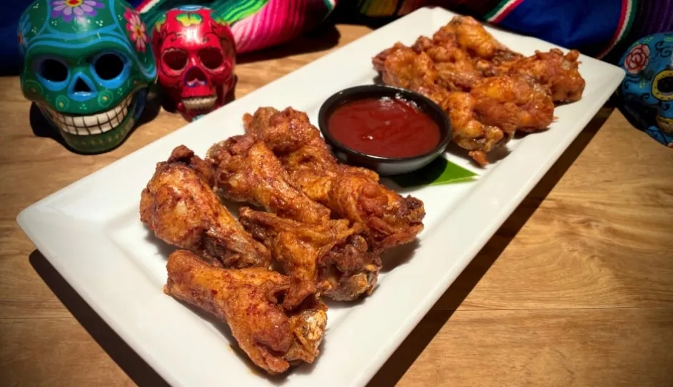 A platter of barbecue chicken wings with dipping sauce