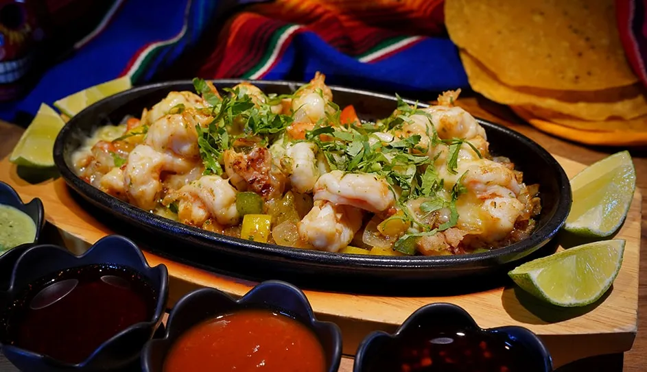Prawns, bacon and chicken alambre on a sizzling skillet with tortillas