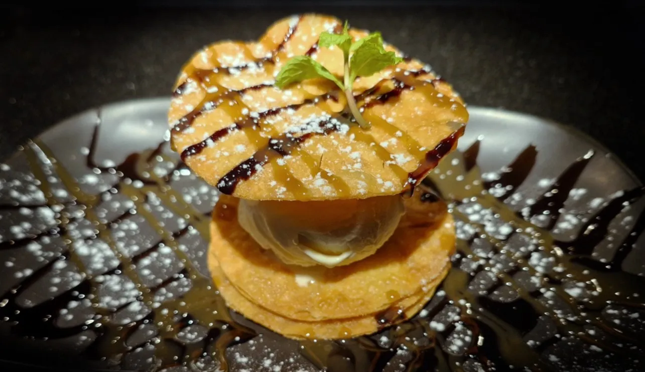 Vanilla ice cream between two crisp wafers, drizzled with chocolate and caramel