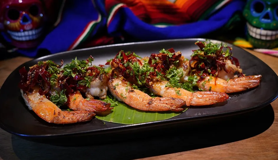 Garlic prawns with Guajillo chilli on a long black plate