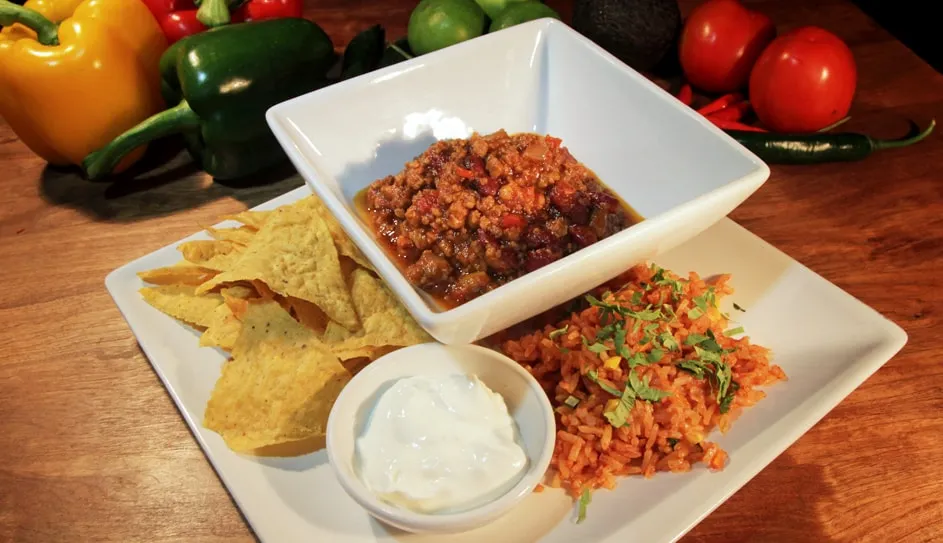 Chili con carne with rice, corn chips and sour cream