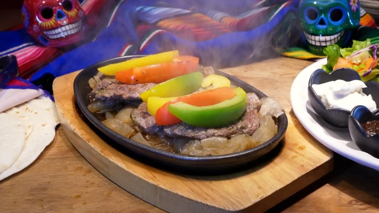 Sizzling beef fajitas with peppers, tortillas and sides