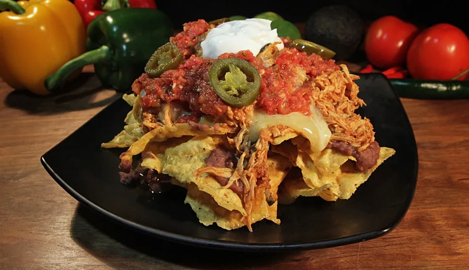 Nachos topped with salsa, sour cream and jalapeños