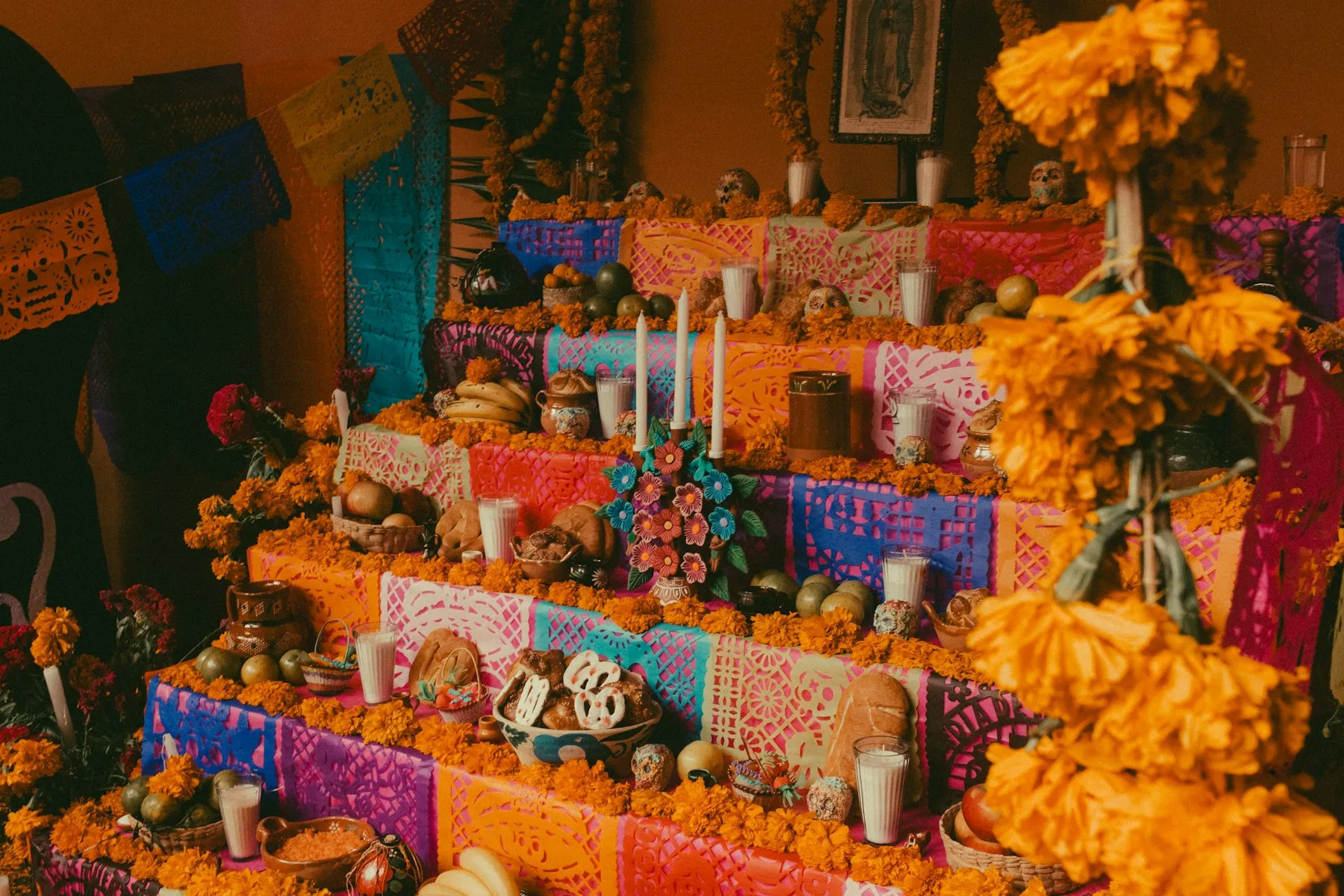 A Día de los Muertos altar with marigolds, candles and sugar skulls