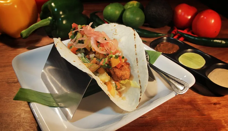 A Baja fish taco with pico de gallo and pickled onions